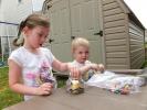 STACEY SOLT/TIMES NEWS Zoe Rodgers, 4, and Andrew Rodgers, 3, make crayon candles on a hot summer day. The craft was part of a lesson on the sun as the sun heated the crayons, they melted to create a colorful candle.