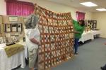 Stacey Solt/Special to the Times News Michele McLaughlin, left, and Beth Bacher discuss a nine-patch quilt from the Civil War era during their presentation "Money, myth and madder: Women and quilting during the Civil War."