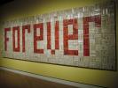This Sept. 27, 2014 photo shows a solid wall of 4,000 paperback romance novels spelling out the word "FOREVER" in an art installation at Crystal Bridges Museum of American Art in Bentonville, Ark. The work by John Salvest was part of a major…