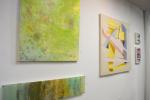Michelle Neifert's acrylic paint and canvas hang along side Ryan Hnat's Geometric abstraction piece in the gallery.