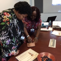 Kayla and Tracey practice to find lumps in breast model