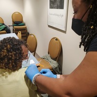 Soror giving her Soror a vaccine.