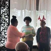 Casandra presenting check to Faith. Janis looks on. 