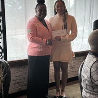 Casandra presenting check to Briana