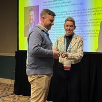 Tyler Silvey accepting the 2025 Rising Nurse Leader award from President Shanon Fucik