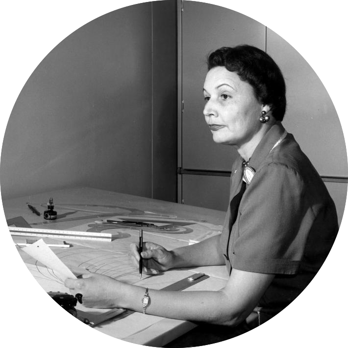 Image: Black and white photo of Mary G. Ross at a desk with a pencil and papers in front of her
