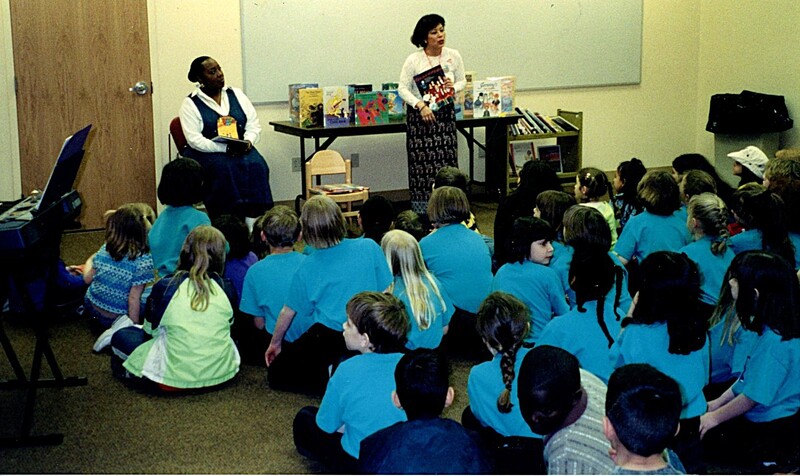 Library associates Ana Trejos (center) and Veronica Parker (left) present a storytime to children attending the Oberlin Choristers program on April 10, 2001.