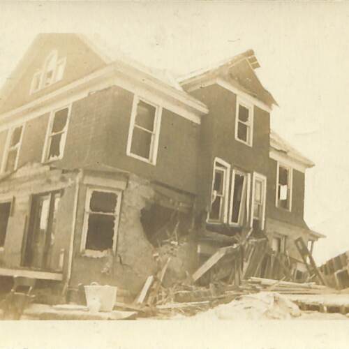 Damaged House with Porch Debris