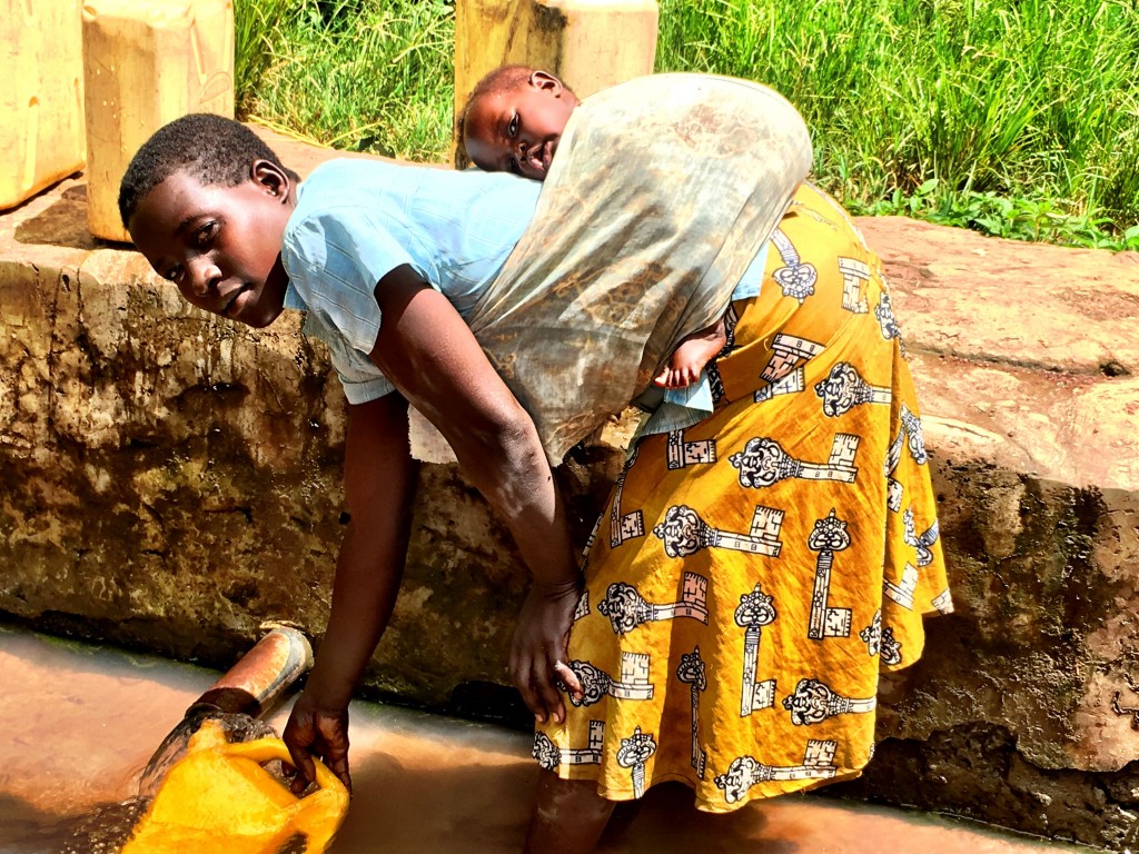 Mongo Alice and her baby fetching water. (Photo credit: Surge)