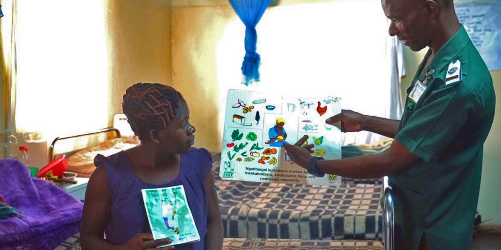 An employee at the maternity home discusses infant care with a pregnant woman.