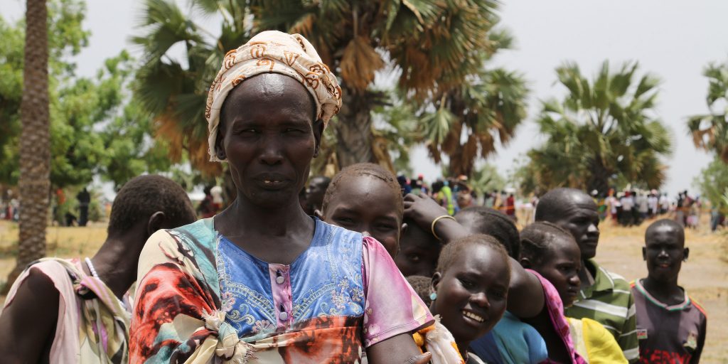 A woman waits at a temporary food distribution site in Leer, South Sudan. (Photo credit: Robert Oxley/DFID)