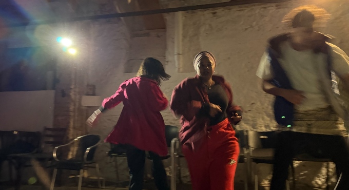 Tres persones corrents en una sala d'assaig. 