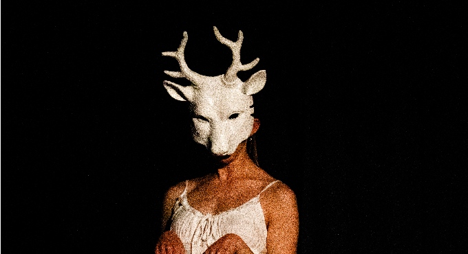 Una noia amb una màscara blanca de cèrvol. 