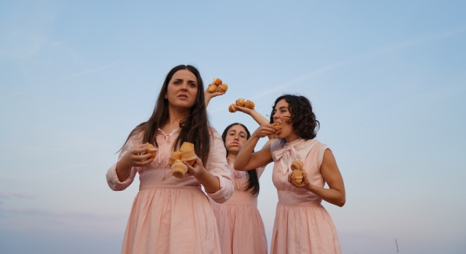 Tres noies amb vestit rosa menjant magdalenes