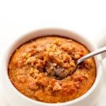 Banana mug cake with a spoon scooping up a bite.