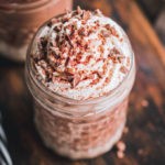 2 chocolate protein milkshake glasses on a cutting board