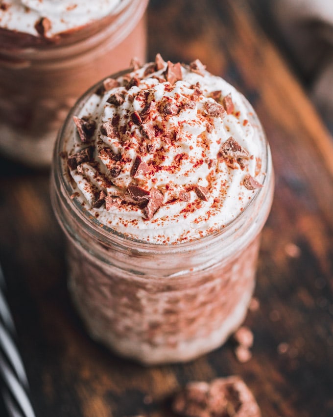 2 chocolate protein milkshake glasses on a cutting board