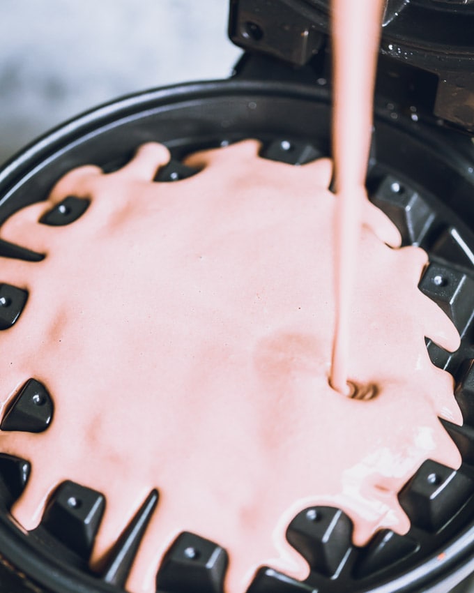 Waffle batter being poured into a waffle iron