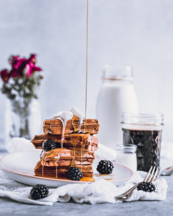 A stack on vegan protein waffles on a white plate