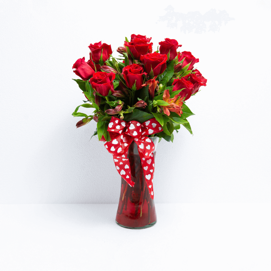 Arreglo de 12 rosas rojas y alstromelias en florero de cristal