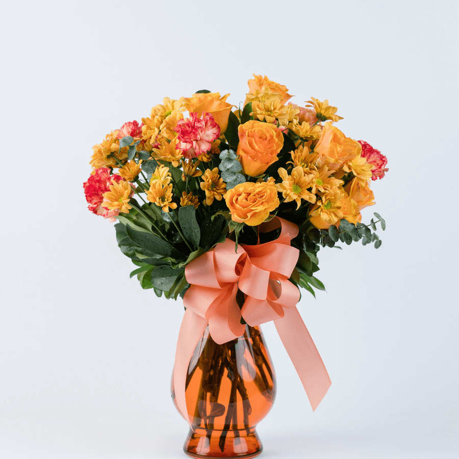Arreglo de 24 flores en jarrón de cristal naranja