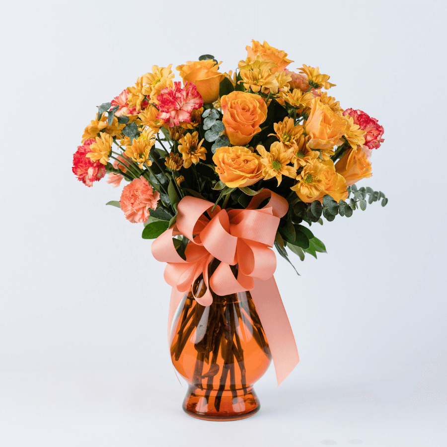 Arreglo de 24 flores en jarrón de cristal naranja