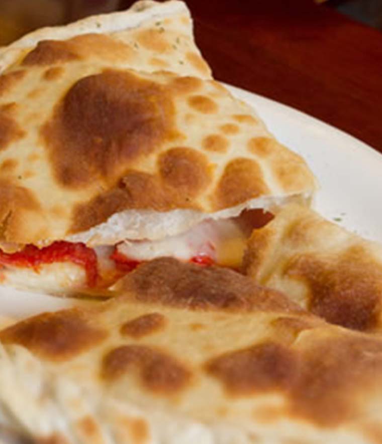 Calzone (mozzarella, hongos, jamón y tomate)