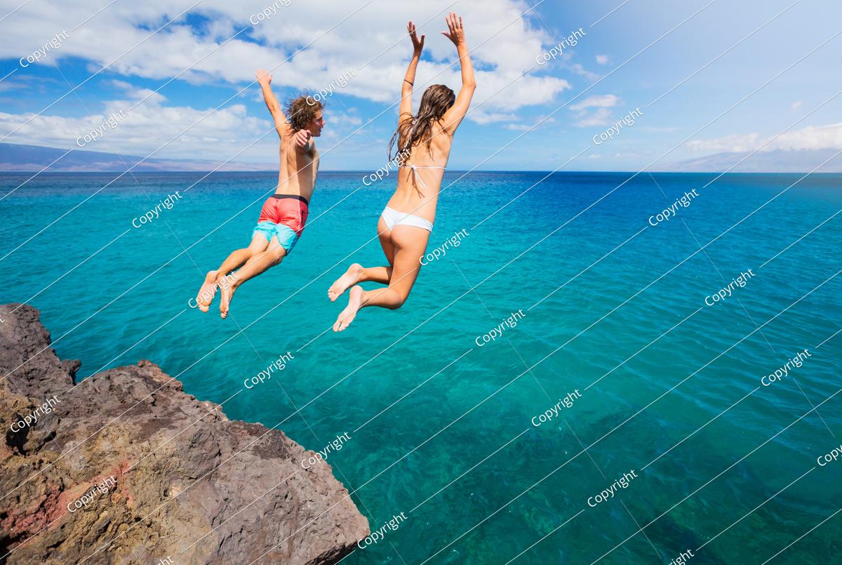 friends cliff jumping into the ocean, summer fun lifestyle.