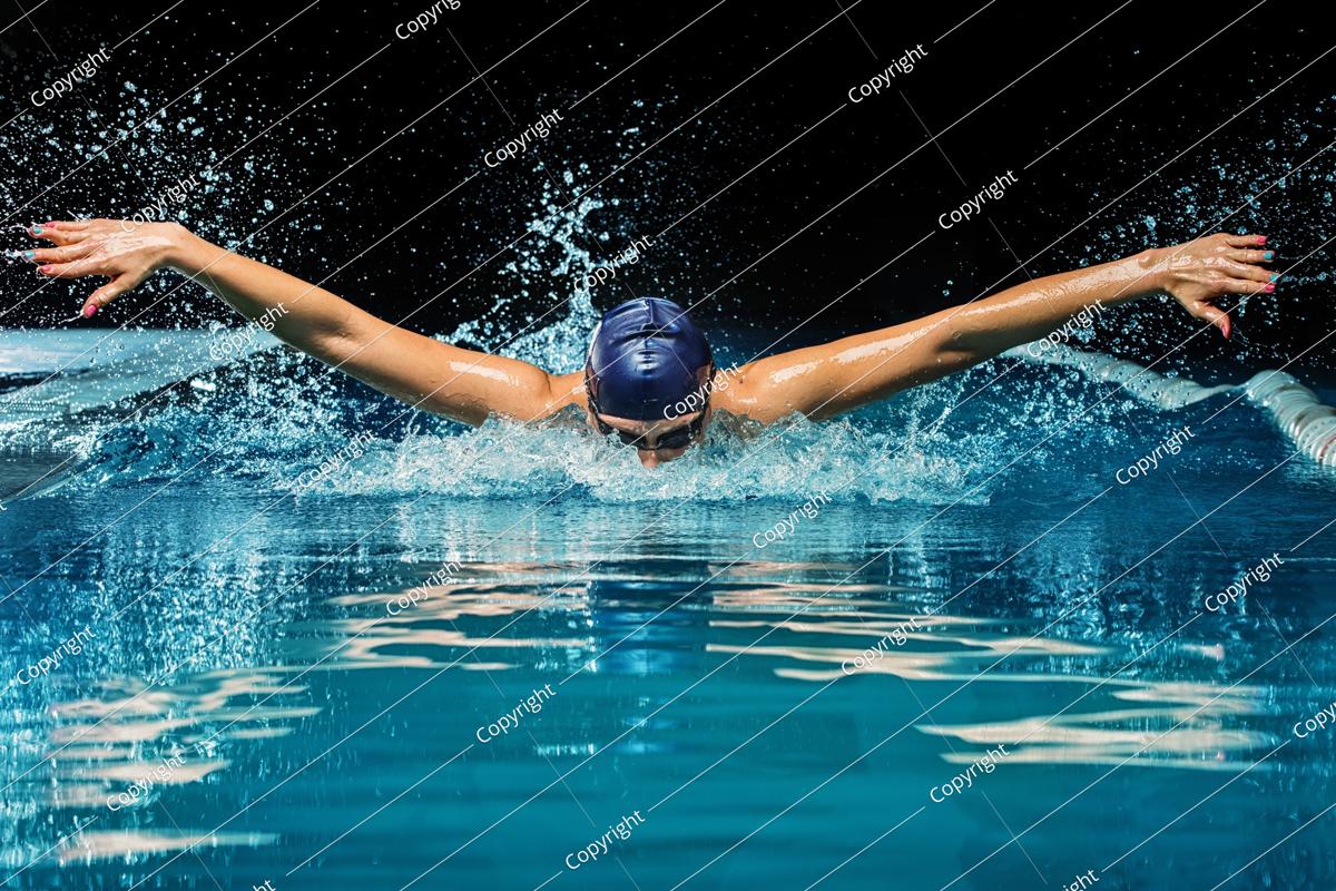 young woman in blue cap and swimming suit in pool