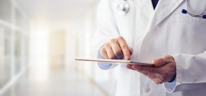 Male doctor using his digital tablet in the hospital Male doctor using his digital tablet in the hospital
