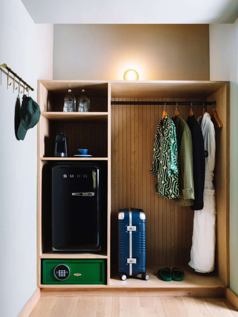 Palihotel Hollywood - open concept closet with hanging clothes, luggage, safe, and mini fridge