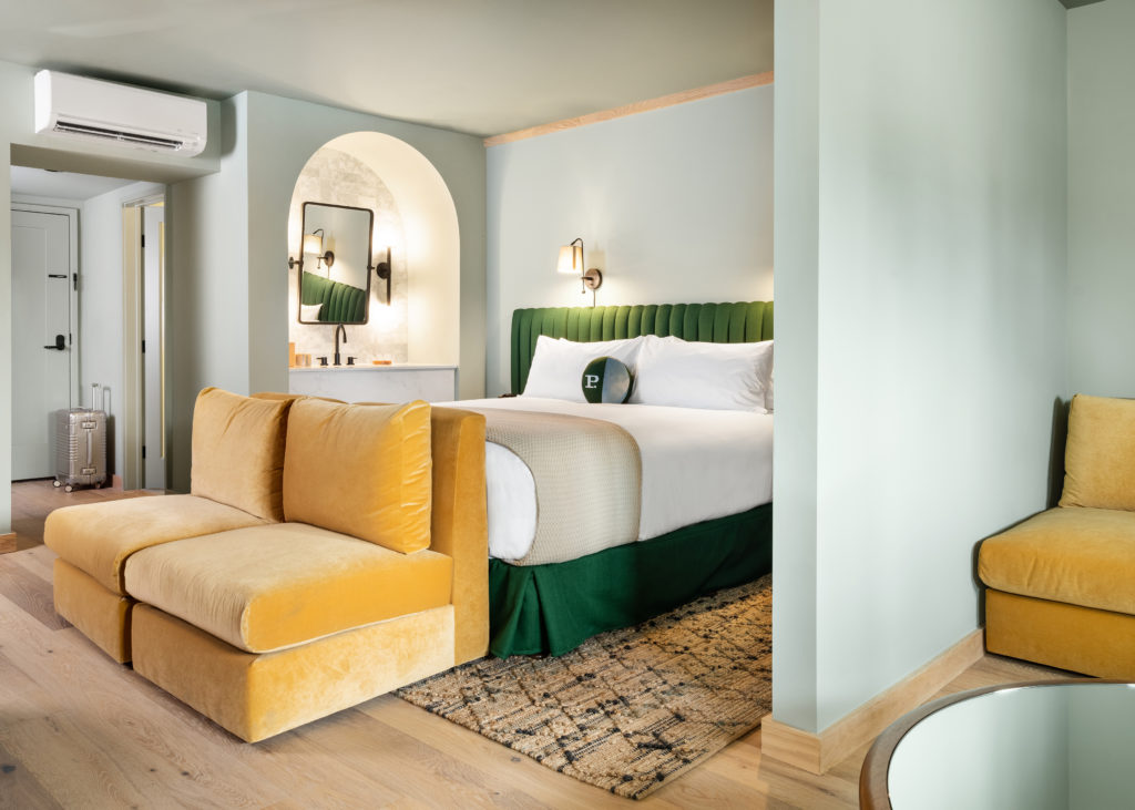 Palihotel Hollywood - wide shot of guestroom with seating area, chairs at foot of the bed, and vanity