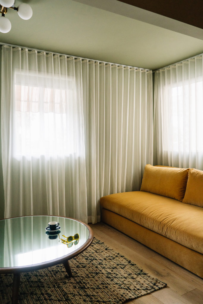 Palihotel Hollywood - guestroom, seating area with plush couch, circular mirrored coffee table on rug
