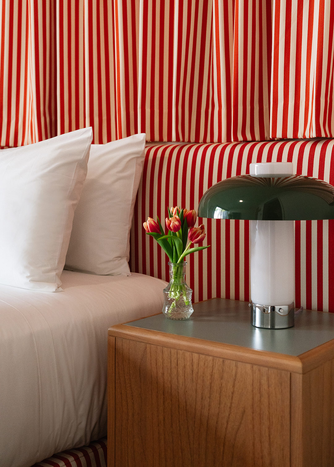 bedside nightstand with flower and lamp