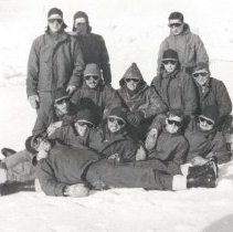 13 sailors in cold weather gear on the ice