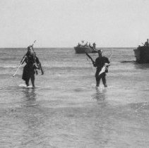 3 sailors headed to shore from landing craft