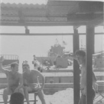 sailors near a shelter, ship in background