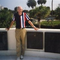Photo of donor with team plaque on top of museum