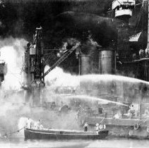 U.S. sailors man boats at the side of the burning U.S.S. West Virginia