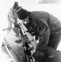Navy Bobsled Team inspecting the blades of the Bobsled