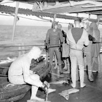 UDT member being assisted with putting on a dry suit