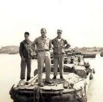 3 Men Standing On Bow Of Small Boat