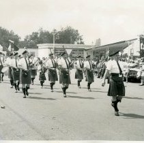 Brian Boru Irish Pipe Band marching in a parade in front of a Phillips 66 s