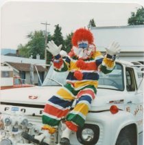 Jack Kelley as clown, sitting on Fall City fire truck, c1970