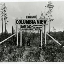 Sign advertising lots in Columbia View, man standing under sign.