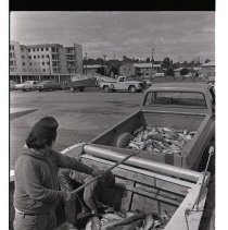 Native American transfers salmon from boat to truck