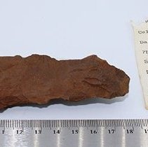 Closeup of adze preform with artifact slip