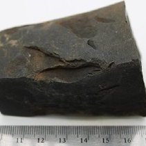 Basalt adze fragment with ruler