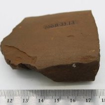 Basalt adze fragment with ruler