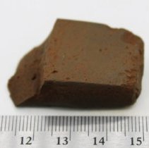 Basalt adze fragment with ruler